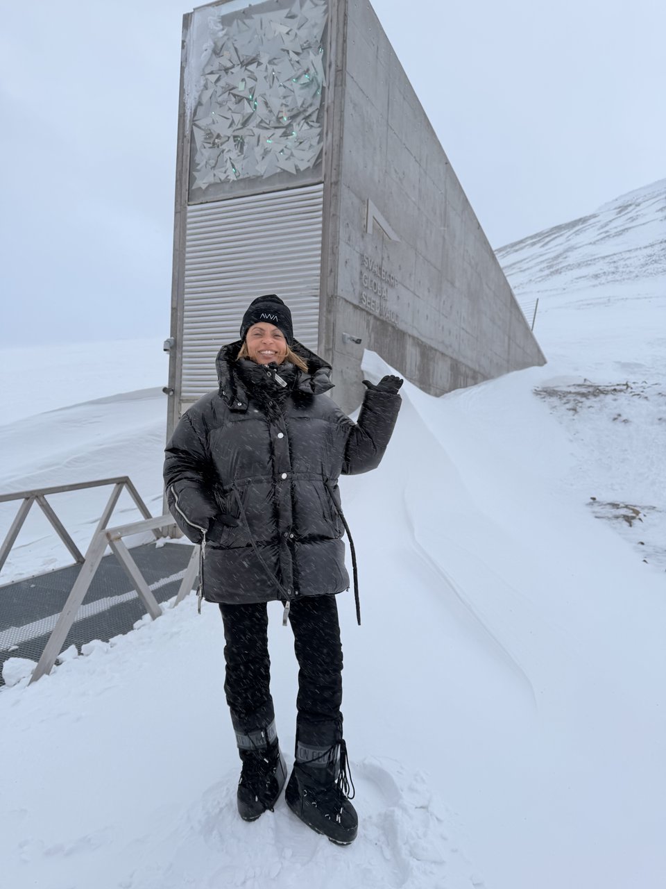 Helem Franceschini diante da entrada do Svalbard Global Seed Vault, sob a neve.