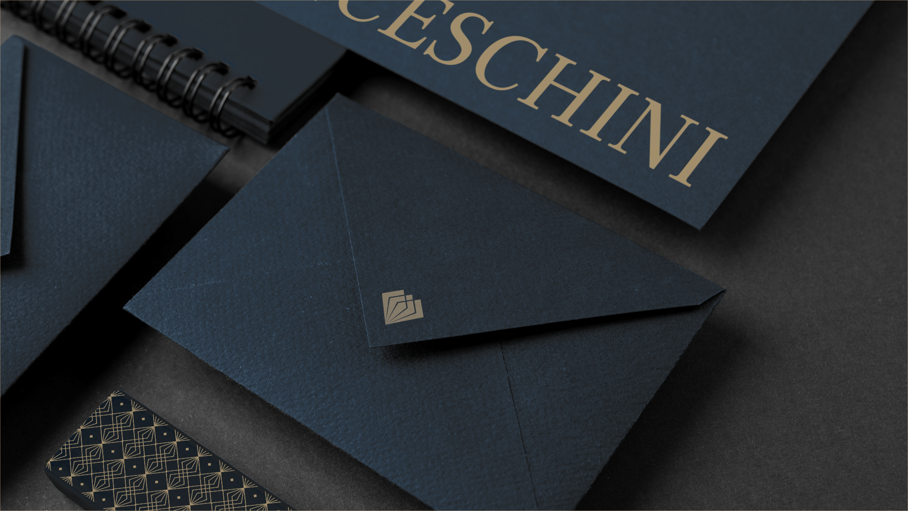 Papelaria e identidade visual do Franceschini Advogados Associados — envelope, cartão e materiais com a marca em tons de safira e dourado